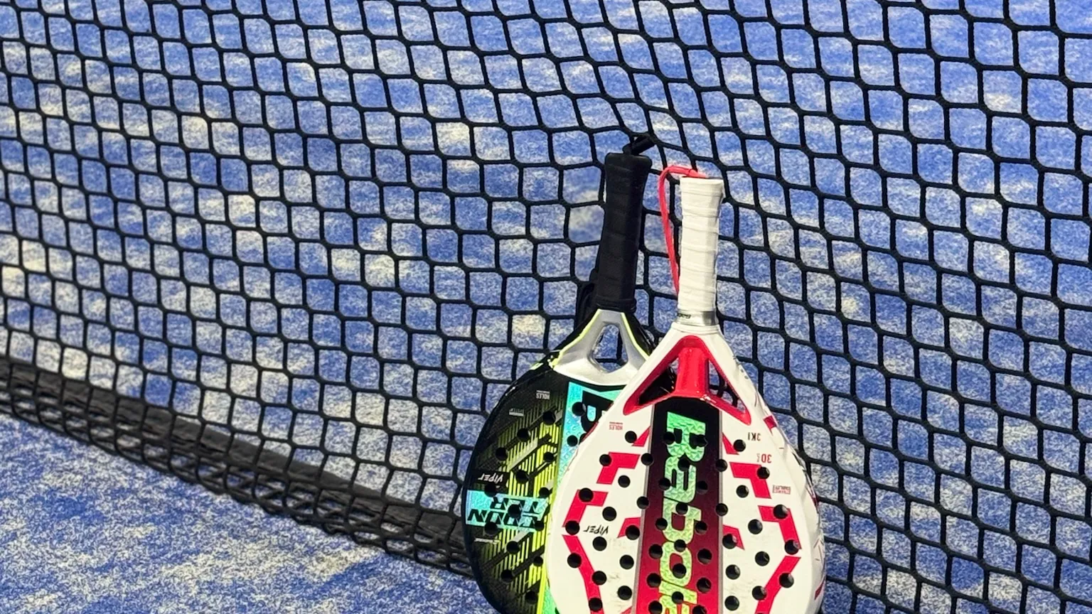 Twee Babolat-rackets en ballen tegen het net
